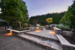 Wide stone steps lead to a patio with a table and chairs